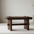 Wooden coffee table in a minimalistic room with light-colored walls and flooring.